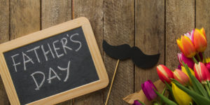 top-view-father-s-day-composition-with-slate-flowers-mustache